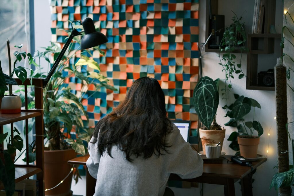 Woman working on laptop at a desk with plants and a clean home office workspace, representing simple affiliate marketing for beginners building an online business